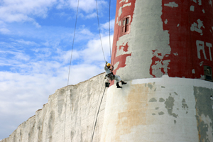 Abseiling painter at work on the Beachy Head Lighthouse